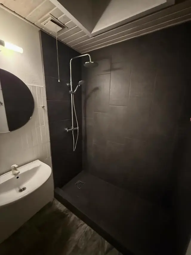 Moderne mørkt badeværelse med storformat-fliser og rain-shower — KVK Murerentreprise